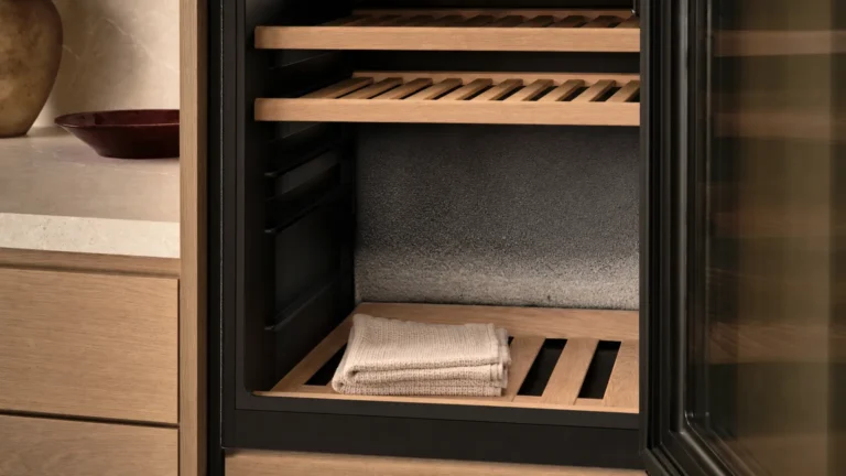 Intérieur d’une cave vidée, fine couche de givre sur la paroi du fond, serviette pliée sur la clayette basse